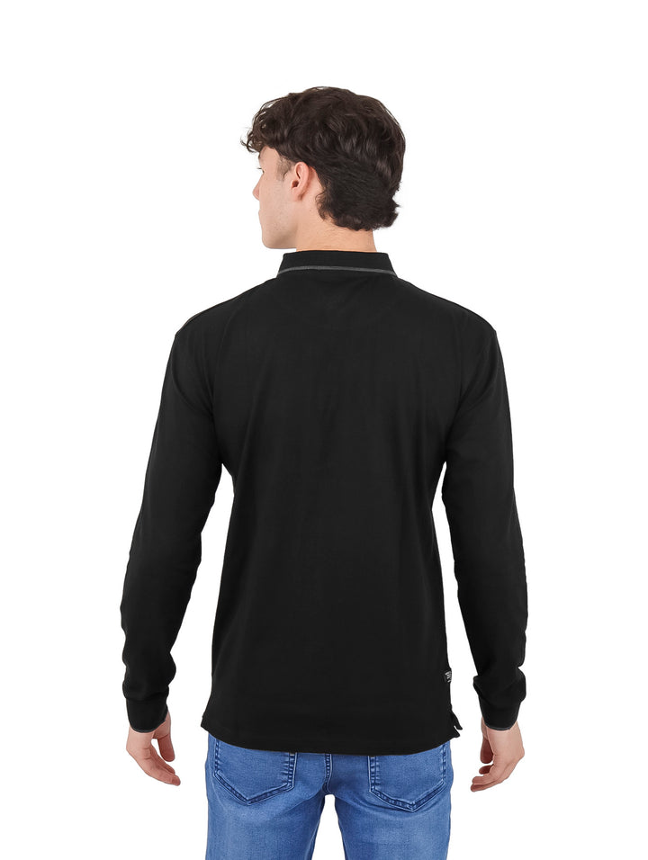 Hombre vistiendo playera polo negra de manga larga con detalles grises en el cuello y los puños.