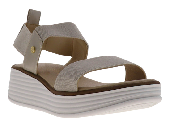 Sandalia de plataforma color beige con tiras elásticas y suela blanca gruesa.