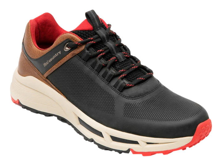 Zapato deportivo Flexi negro con detalles en café, suela blanca y acentos rojos.