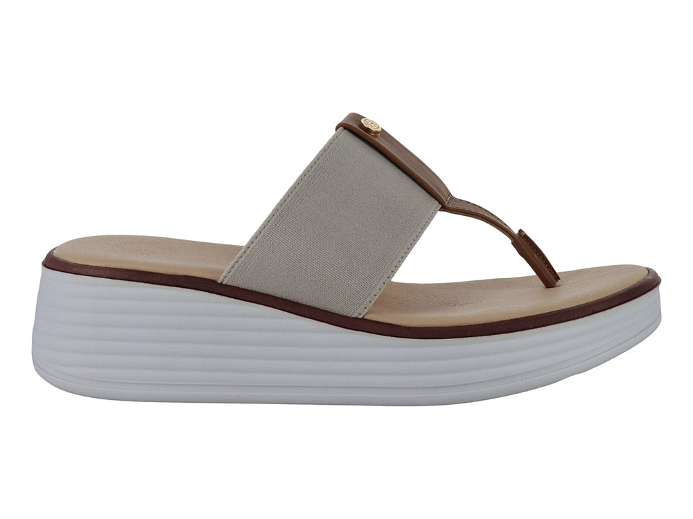 Sandalia de cuña beige con correa elástica y detalle marrón sobre suela blanca.
