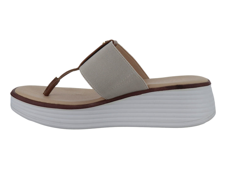 Sandalia de cuña beige con correa elástica y detalle marrón sobre suela blanca.