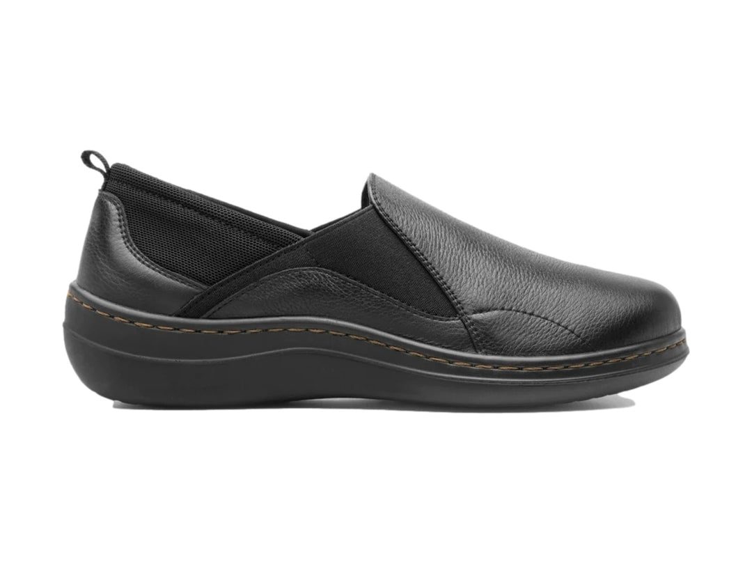 Zapato slip-on Flexi de cuero color negro con costuras marrones y punta redondeada.