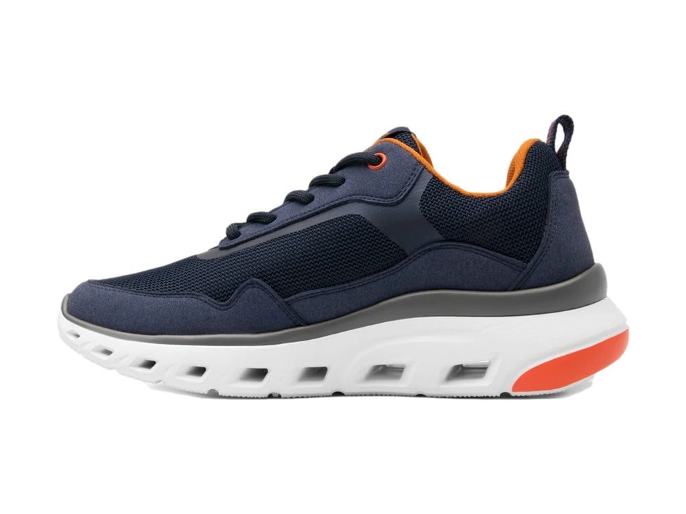 Tenis deportivos Flexi en color azul marino con suela blanca y detalles en naranja.