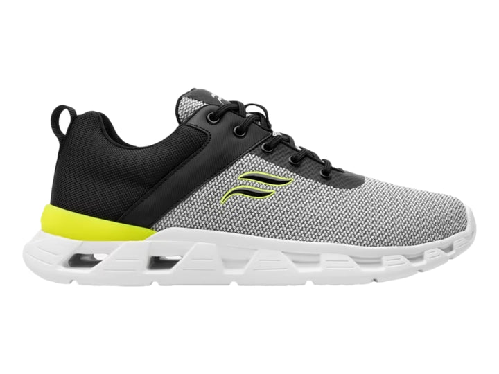 Tenis deportivos Flexi en colores gris, negro y blanco con detalle amarillo en el talón.