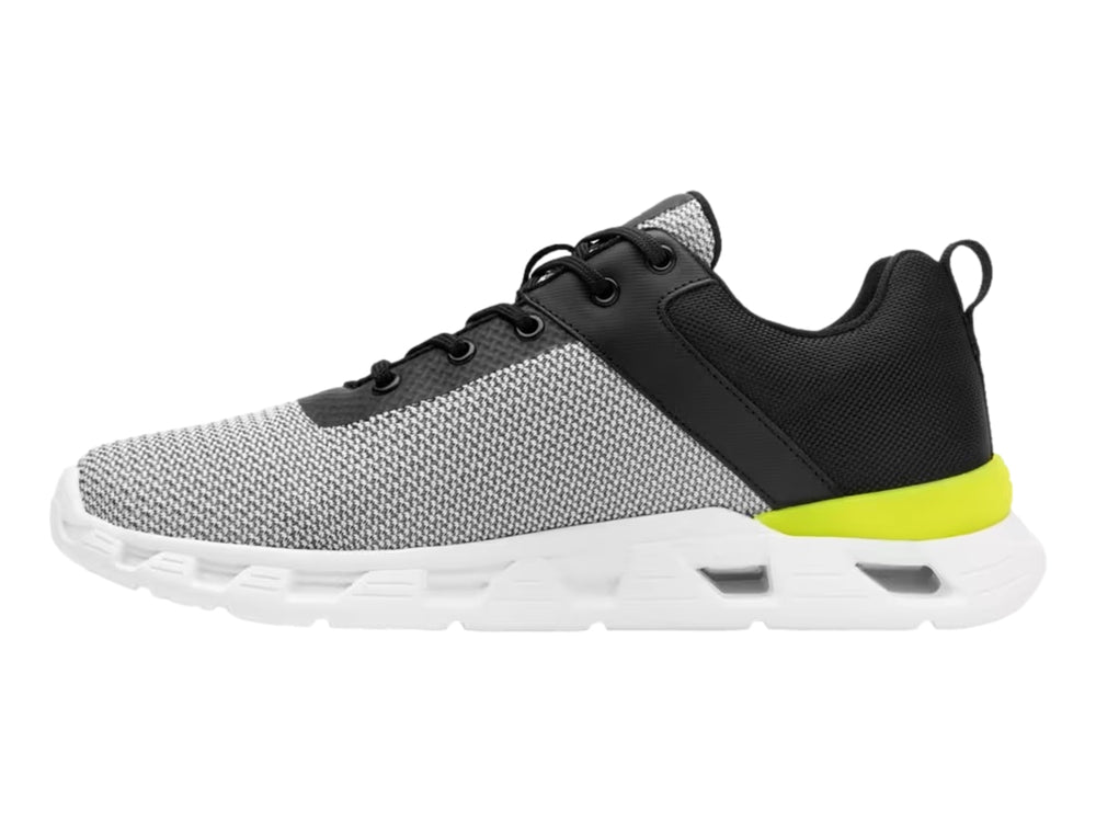 Tenis deportivos Flexi en colores gris, negro y blanco con detalle amarillo en el talón.