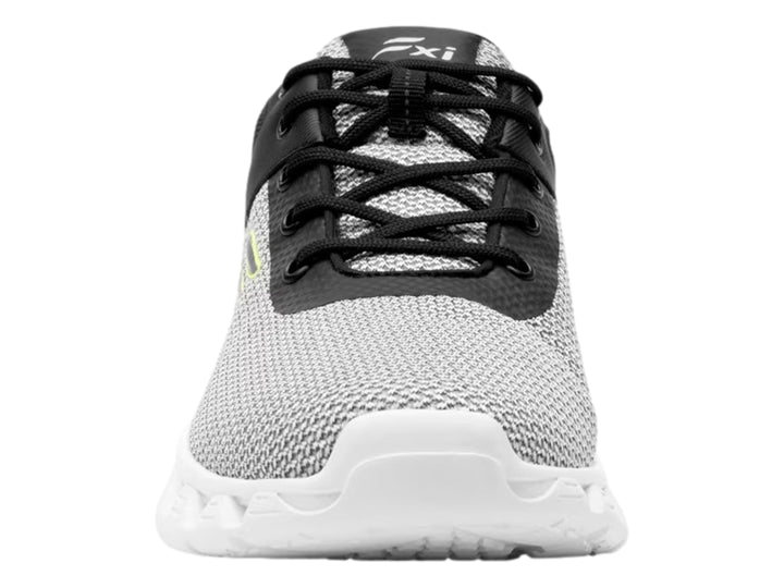 Tenis deportivos Flexi en colores gris, negro y blanco con detalle amarillo en el talón.