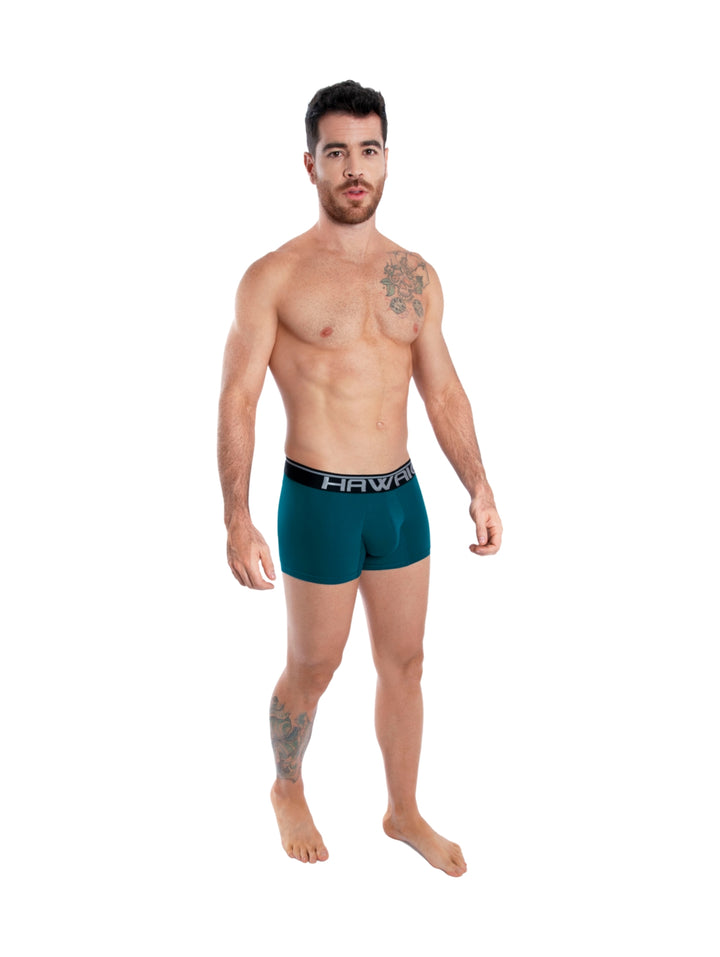 Hombre modelando boxer ajustado color azul petróleo con banda elástica en la cintura.