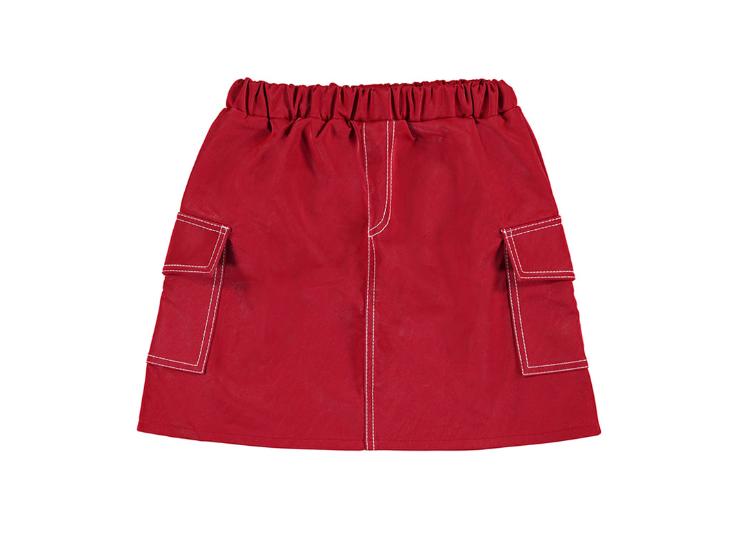 Falda roja de polipiel para niña con cintura elástica y bolsillos laterales con costuras blancas.