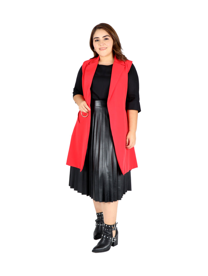 Mujer vistiendo una falda plisada de color negro en material sintético brillante.