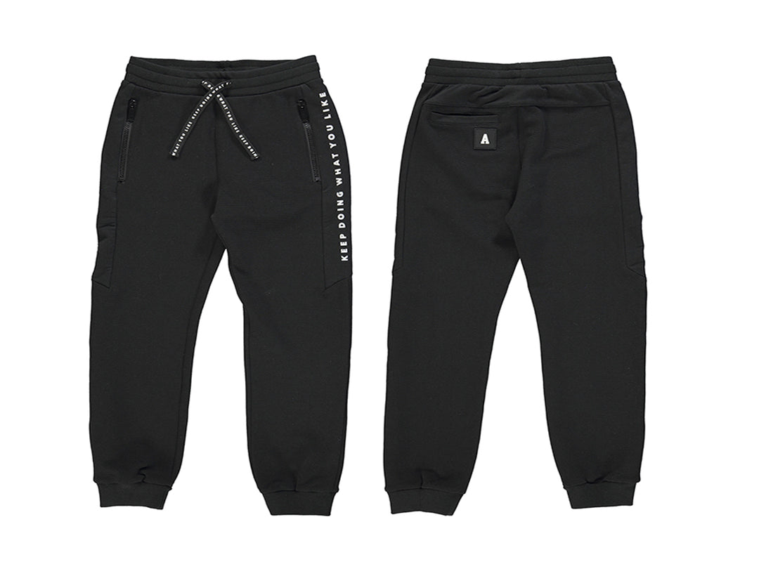 Pantalón de felpa negro para niño con cordón ajustable y texto blanco en el lateral.