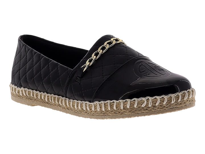 Alpargata negra para mujer con diseño acolchado, cadena dorada y suela de fibras naturales.