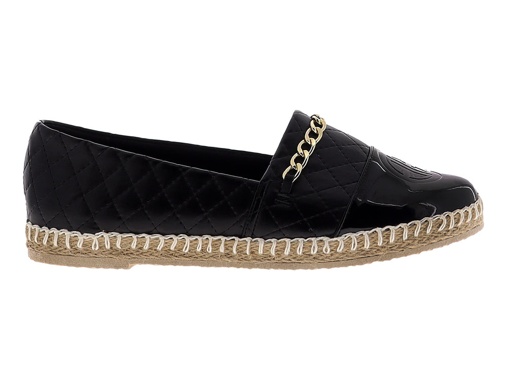 Alpargata negra para mujer con diseño acolchado, cadena dorada y suela de fibras naturales.