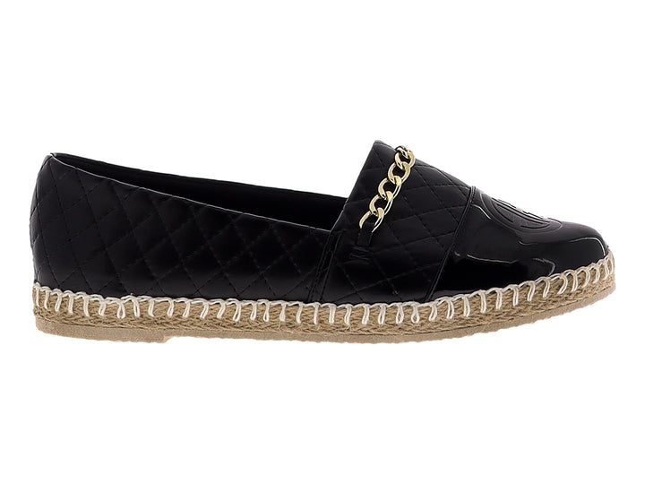 Alpargata negra para mujer con diseño acolchado, cadena dorada y suela de fibras naturales.