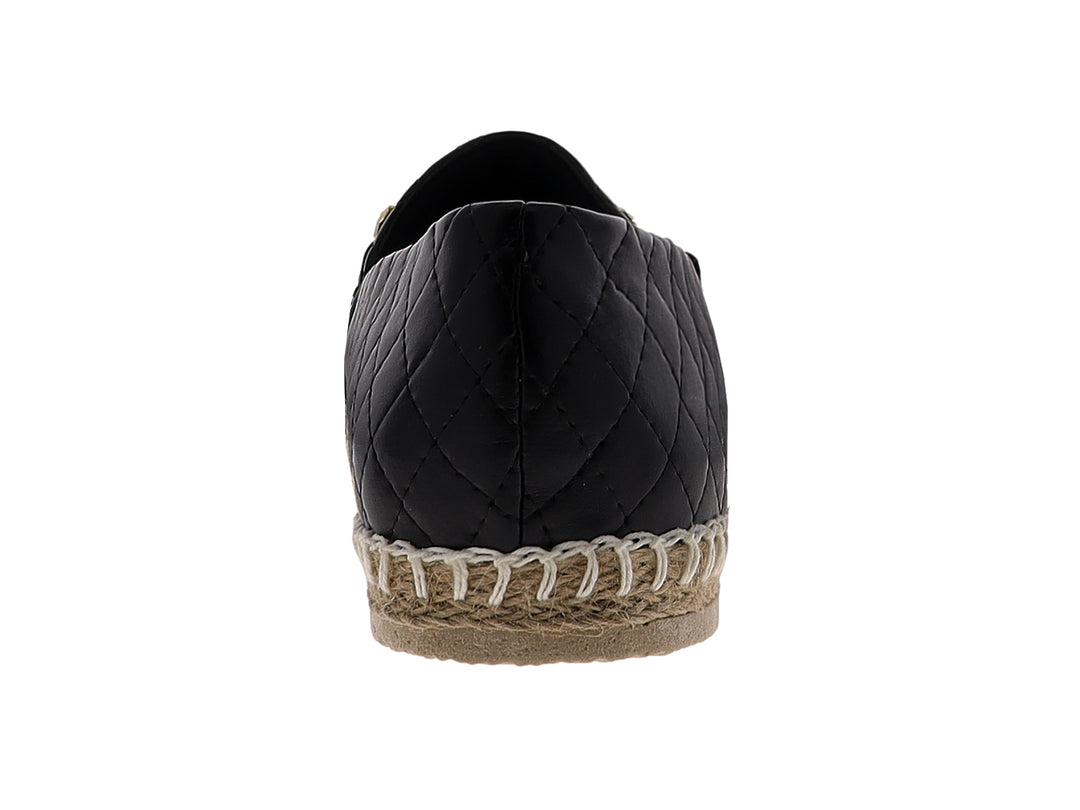 Alpargata negra para mujer con diseño acolchado, cadena dorada y suela de fibras naturales.