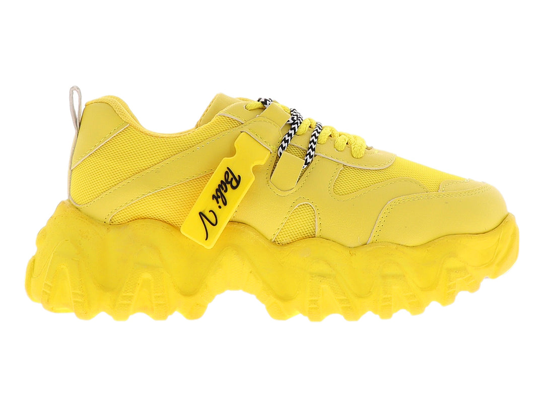 Tenis deportivos color amarillo con suela chunky y agujetas con detalles en blanco y negro.