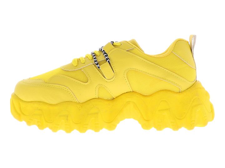 Tenis deportivos color amarillo con suela chunky y agujetas con detalles en blanco y negro.