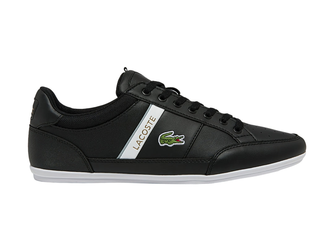 Tenis Lacoste color negro con franja blanca lateral y suela blanca.