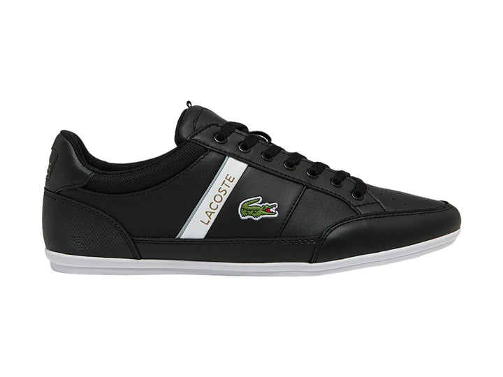 Tenis Lacoste color negro con franja blanca lateral y suela blanca.