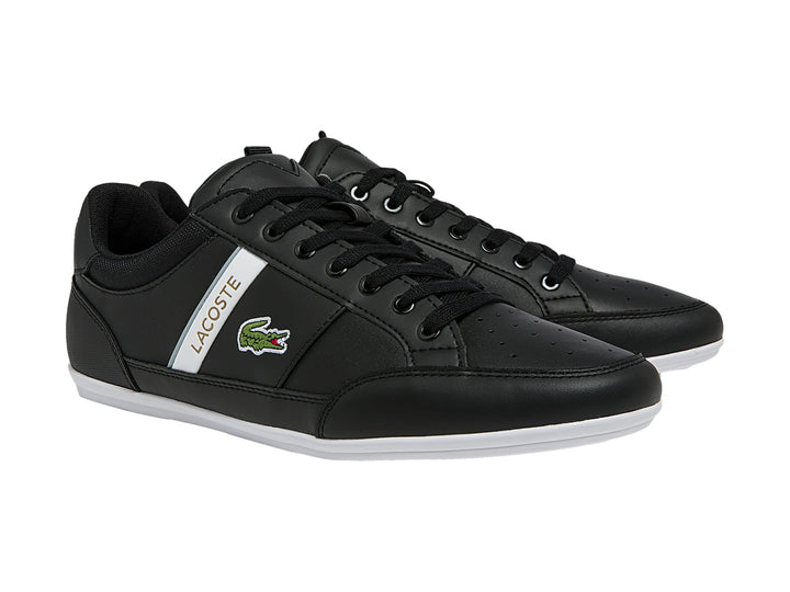 Tenis Lacoste color negro con franja blanca lateral y suela blanca.