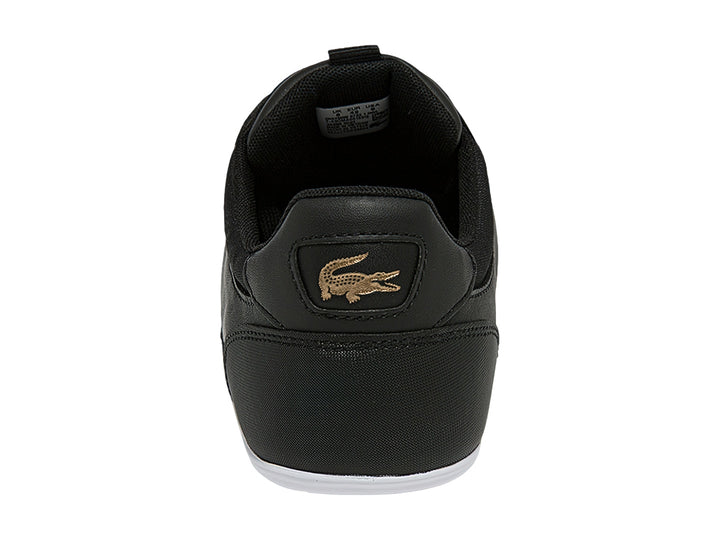 Tenis Lacoste color negro con franja blanca lateral y suela blanca.