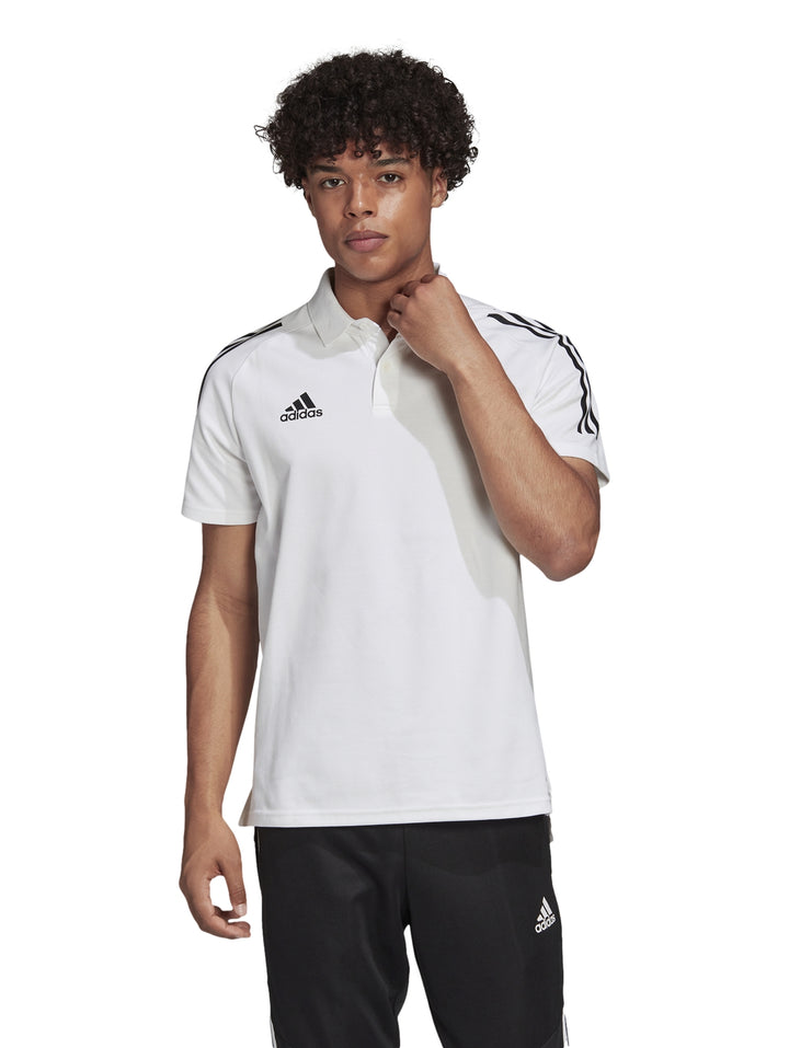 Hombre vistiendo playera polo blanca de Adidas con rayas negras en los hombros.