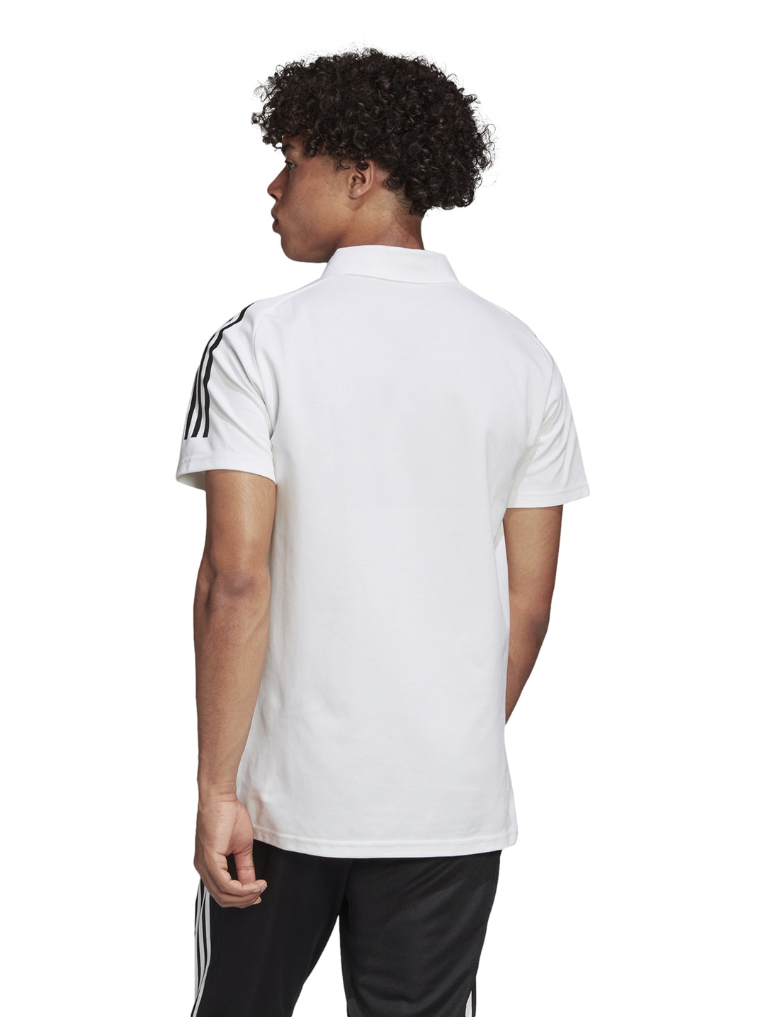 Hombre vistiendo playera polo blanca de Adidas con rayas negras en los hombros.