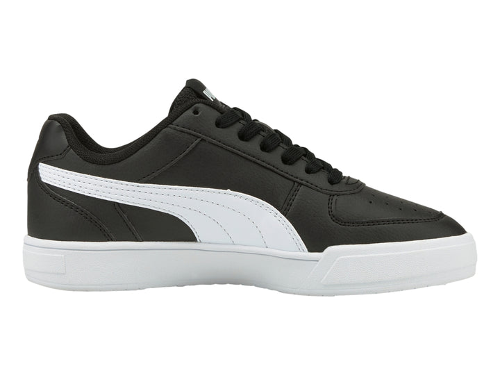Tenis PUMA Caven JR en color negro con franja lateral y suela en color blanco para niño.