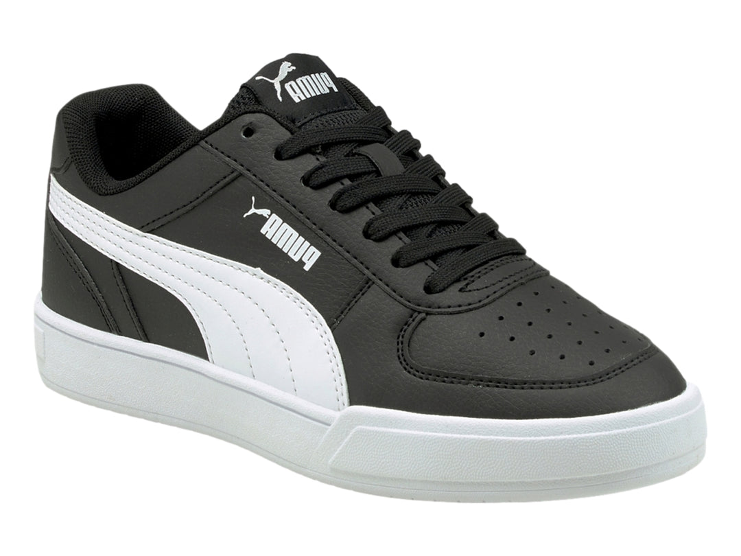 Tenis PUMA Caven JR en color negro con franja lateral y suela en color blanco para niño.