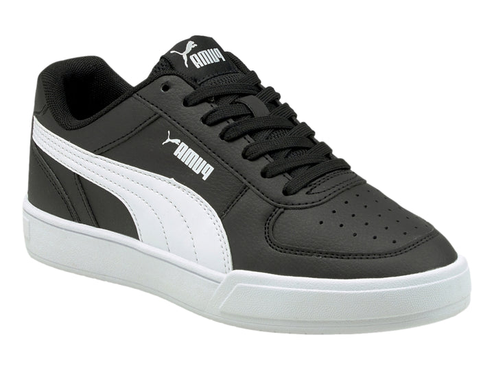 Tenis PUMA Caven JR en color negro con franja lateral y suela en color blanco para niño.