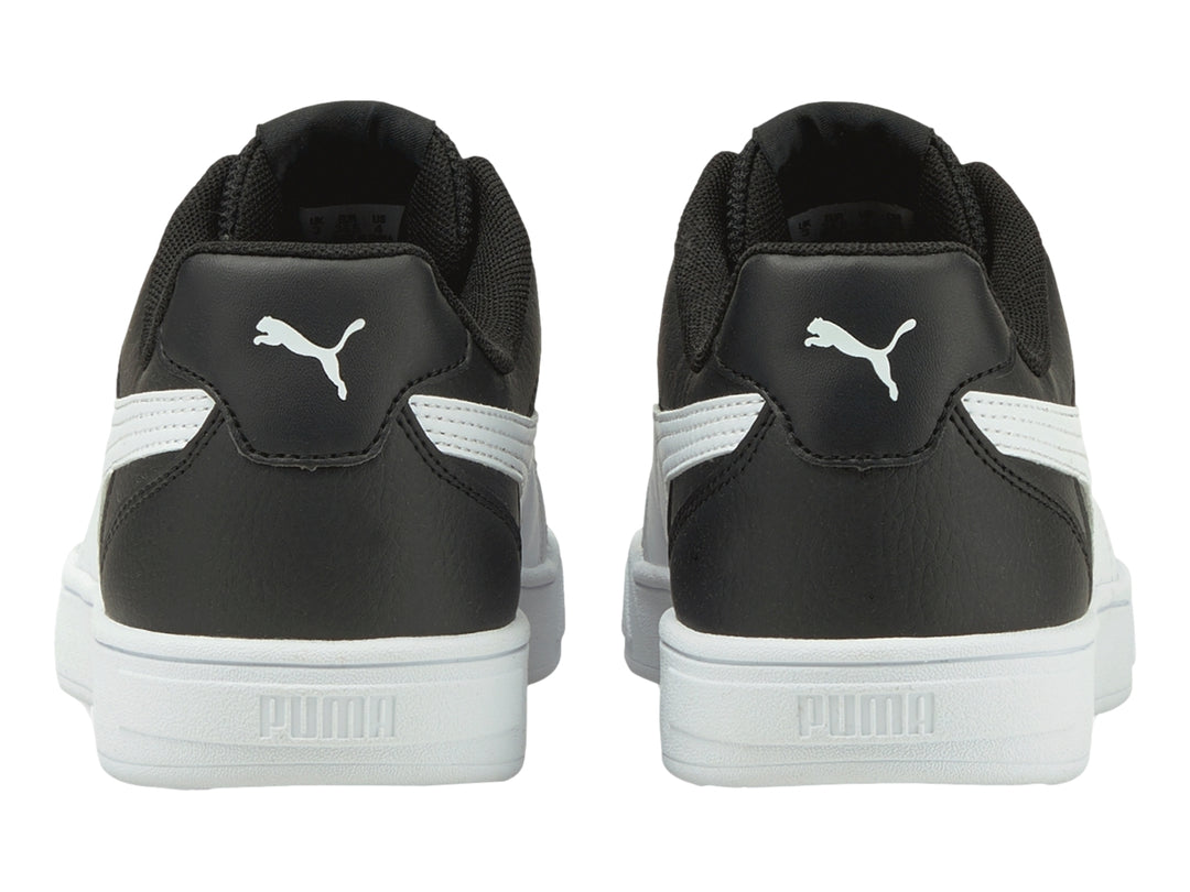 Tenis PUMA Caven JR en color negro con franja lateral y suela en color blanco para niño.