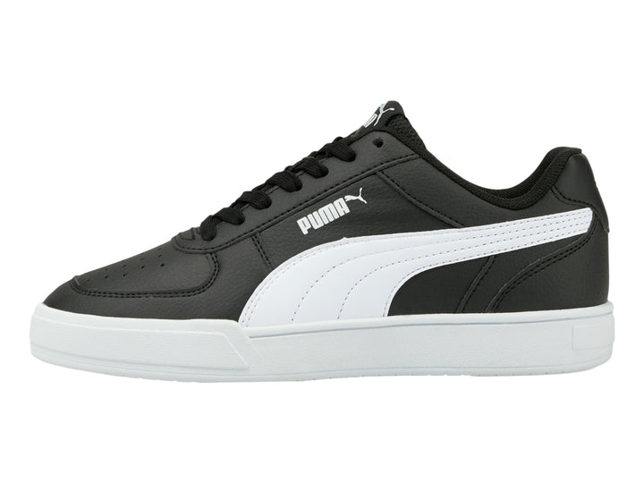 Tenis PUMA Caven JR en color negro con franja lateral y suela en color blanco para niño.