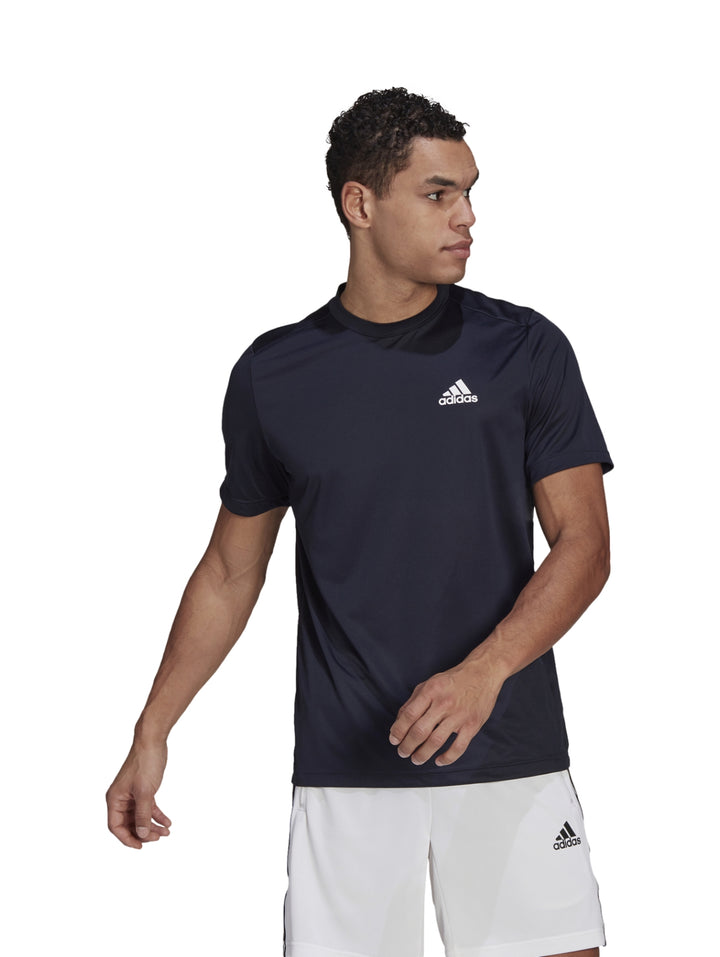 Hombre usando playera deportiva Adidas color azul marino con logotipo blanco.