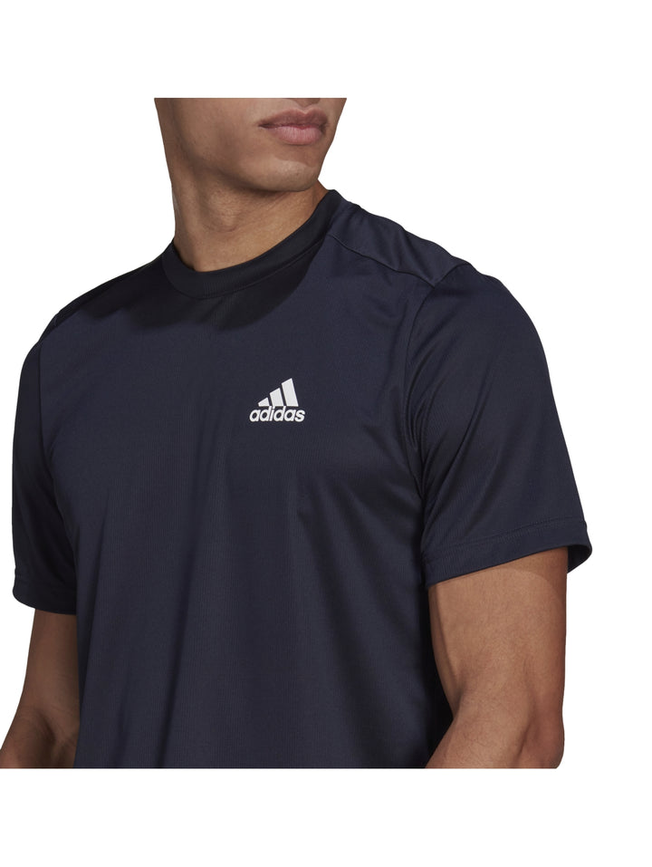 Hombre usando playera deportiva Adidas color azul marino con logotipo blanco.