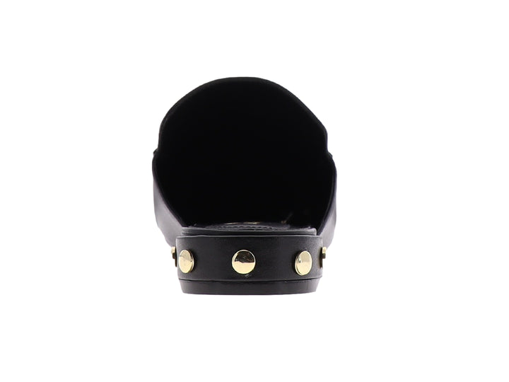 Zapato mule de cuero negro con herraje metálico dorado en la parte superior.