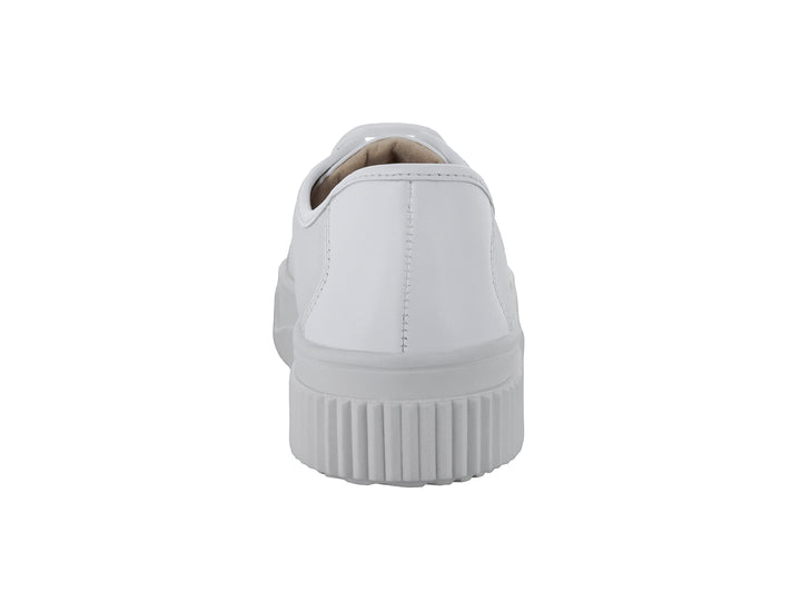 Tenis blancos de cuero con suela gruesa y estriada.