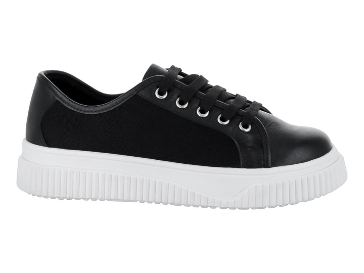 Tenis negros con suela blanca gruesa y cordones negros.