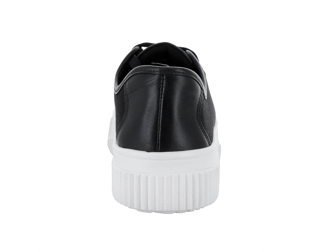 Tenis negros con suela blanca gruesa y cordones negros.