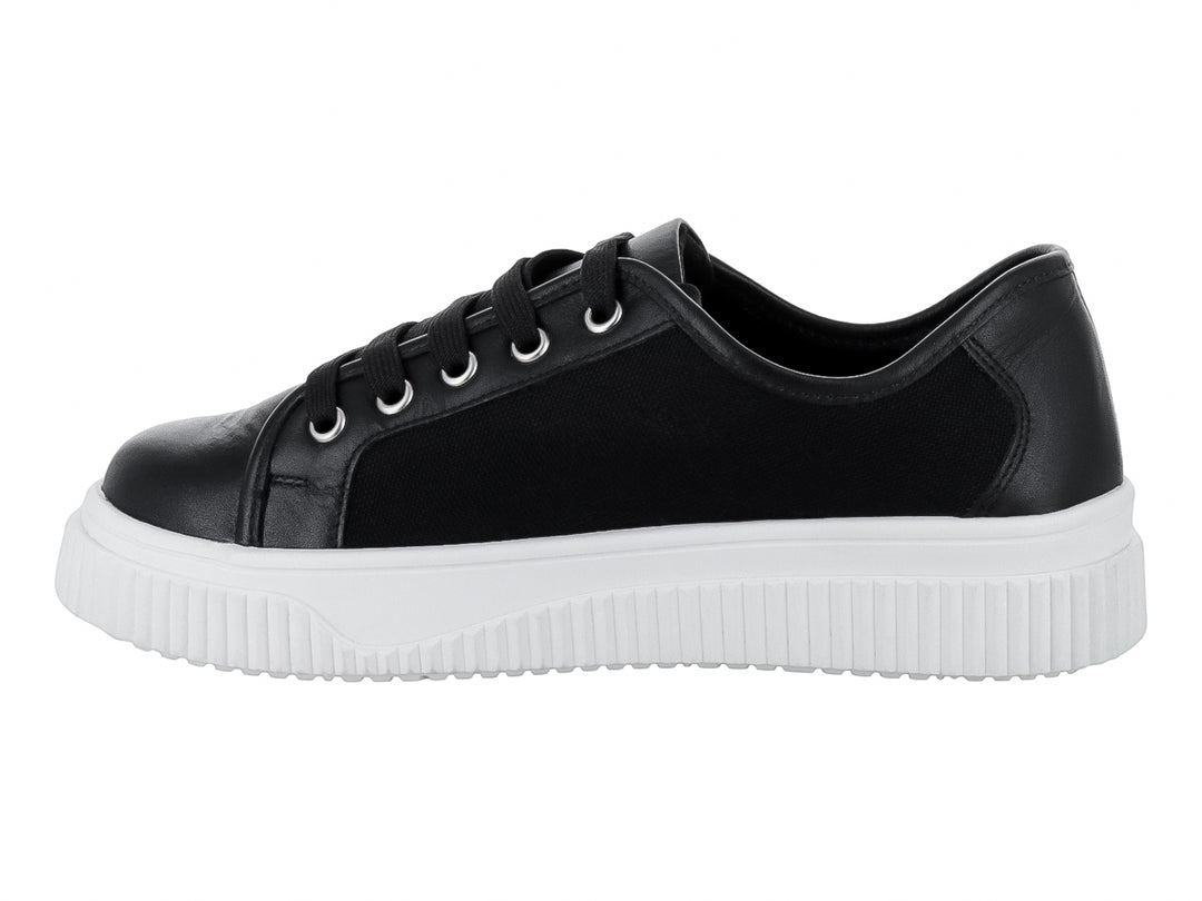 Tenis negros con suela blanca gruesa y cordones negros.
