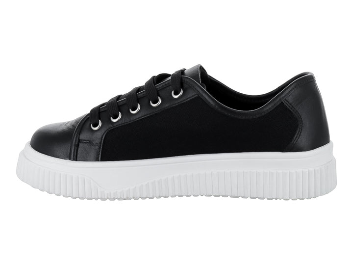 Tenis negros con suela blanca gruesa y cordones negros.