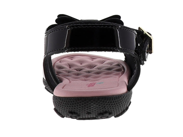 Sandalia negra de charol para niña con moño frontal y plantilla rosa.