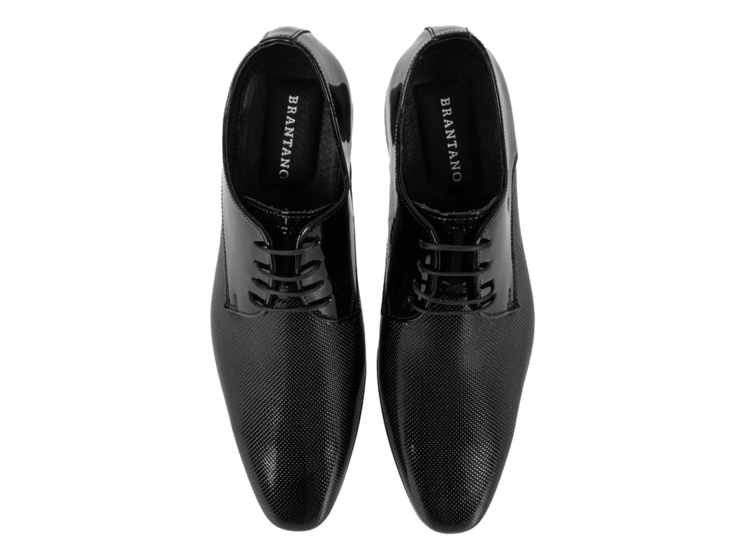 Zapato de vestir negro para hombre con acabado en charol y detalles texturizados.