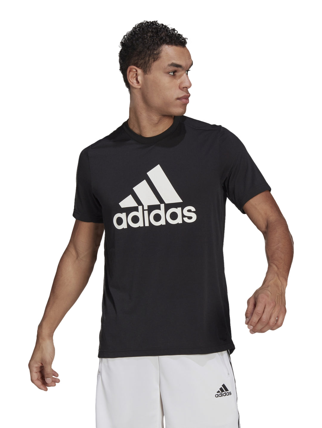 Hombre vistiendo playera deportiva Adidas color negro con logotipo blanco en el pecho.