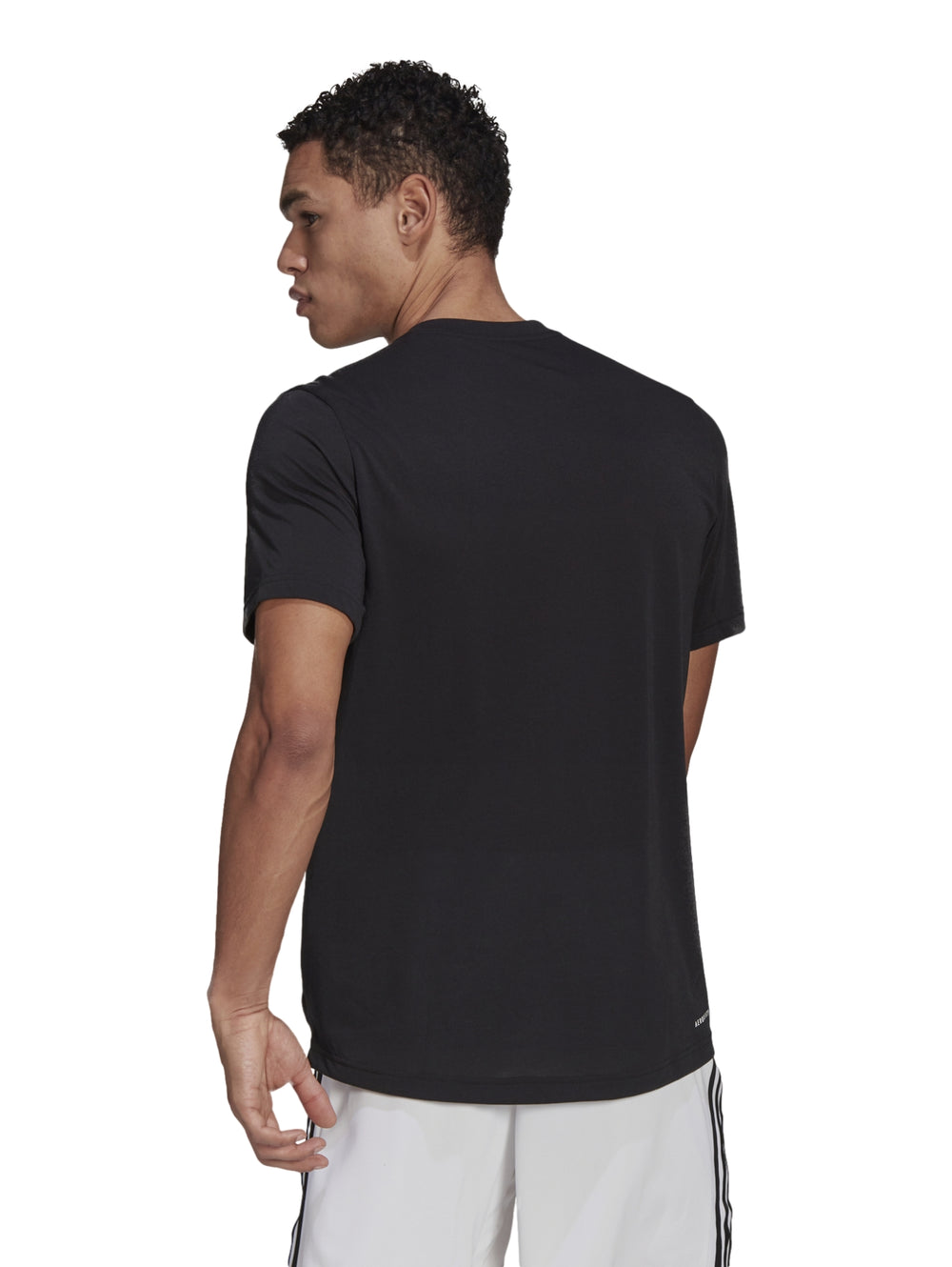 Hombre vistiendo playera deportiva Adidas color negro con logotipo blanco en el pecho.