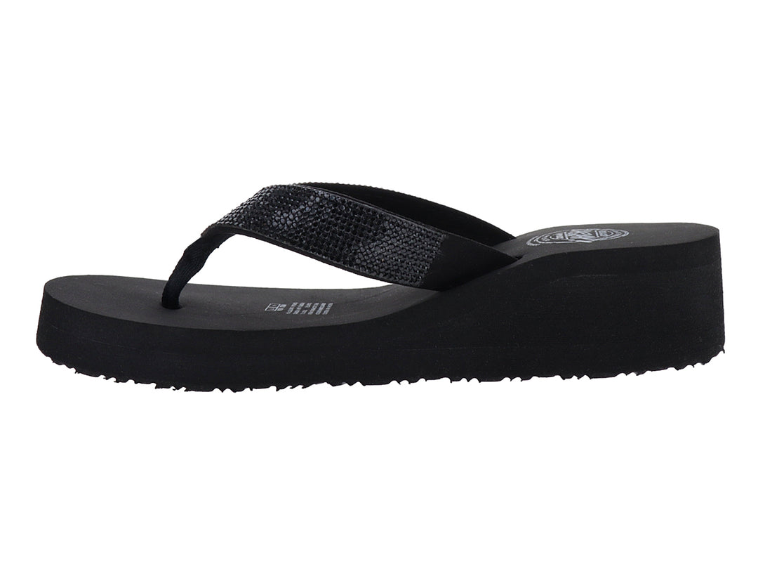 Sandalias negras de plataforma con tira brillante tipo flip-flop.