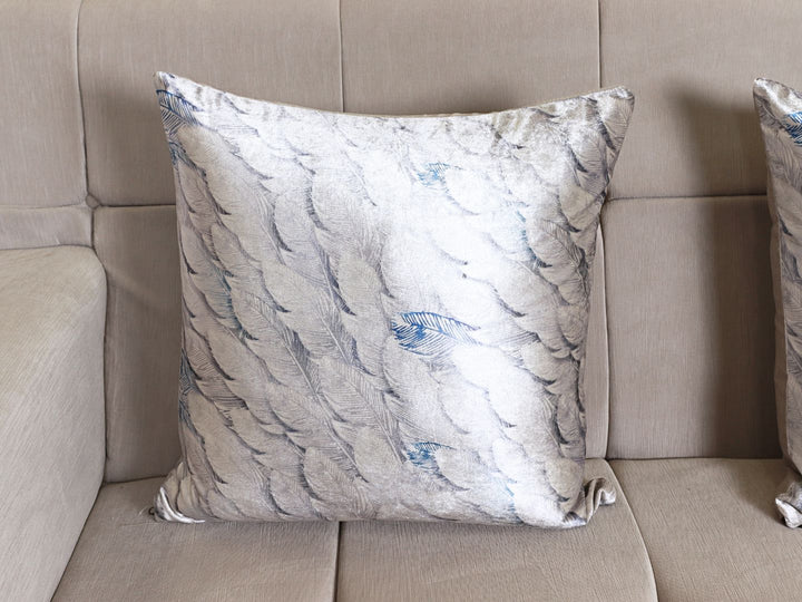 Conjunto de dos sofás color blanco nieve con cojines decorativos en tonos grises y azules.