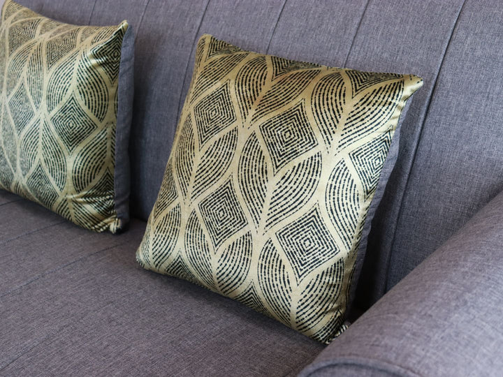 Conjunto de sala color silver compuesto por un sofá de tres plazas y uno de dos plazas con cojines decorativos verdes.