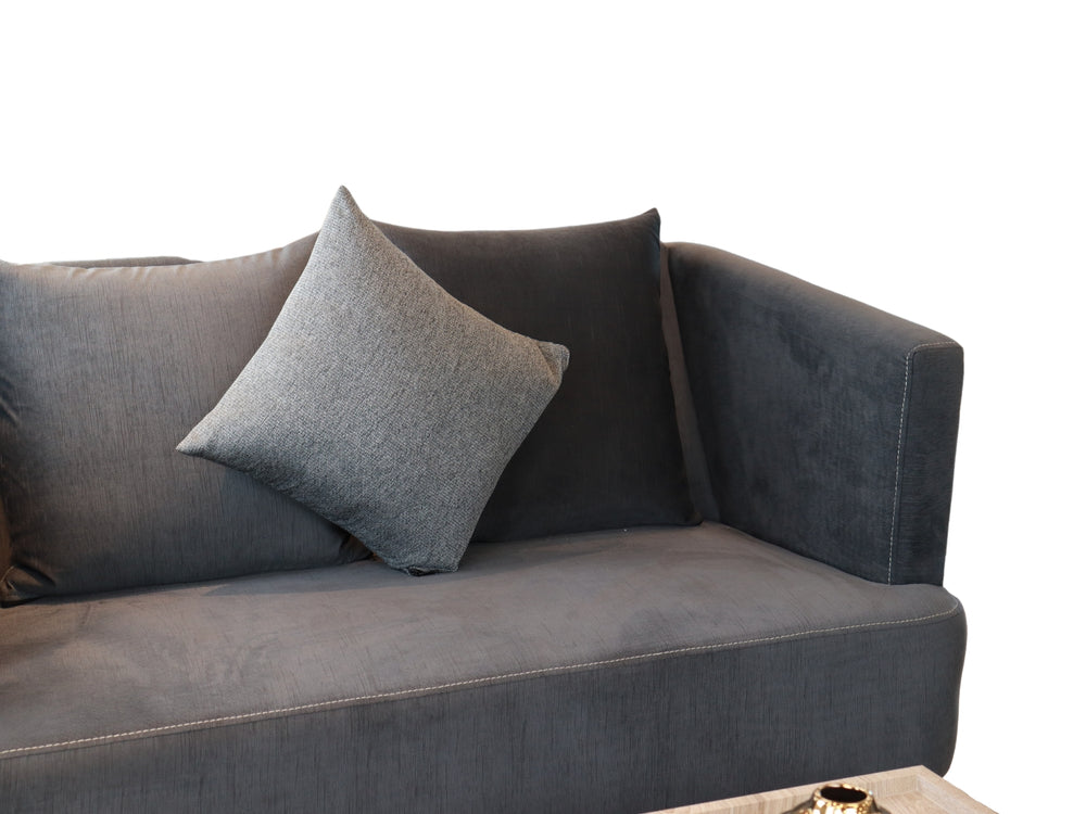 Conjunto de sala compuesto por dos sofás color gris con cojines y una mesa de centro rectangular.
