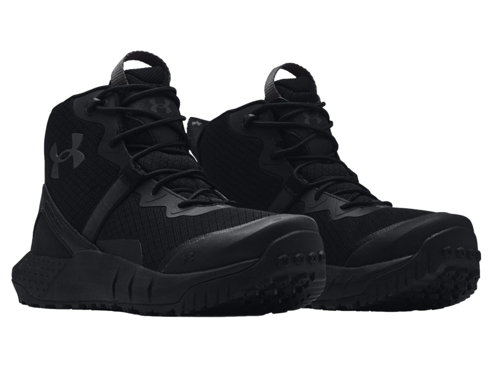 Bota deportiva Under Armour de color negro, corte medio con suela robusta y textura de malla.