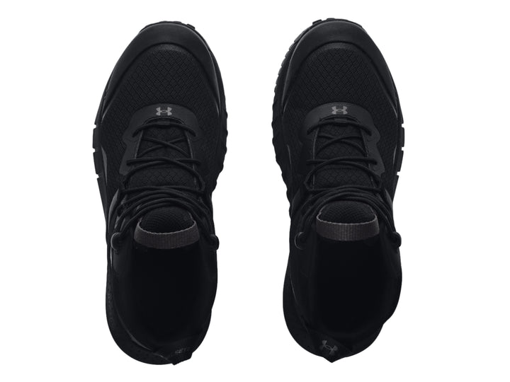 Bota deportiva Under Armour de color negro, corte medio con suela robusta y textura de malla.