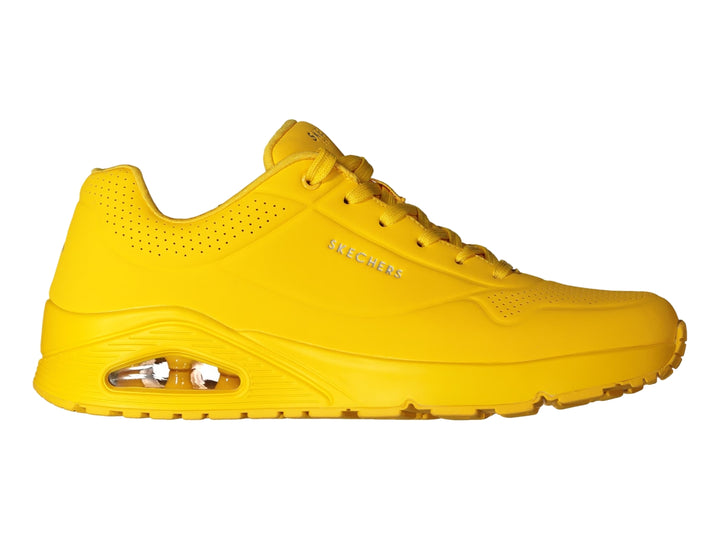 Tenis deportivos Skechers color amarillo brillante con suela amortiguada y detalles perforados.